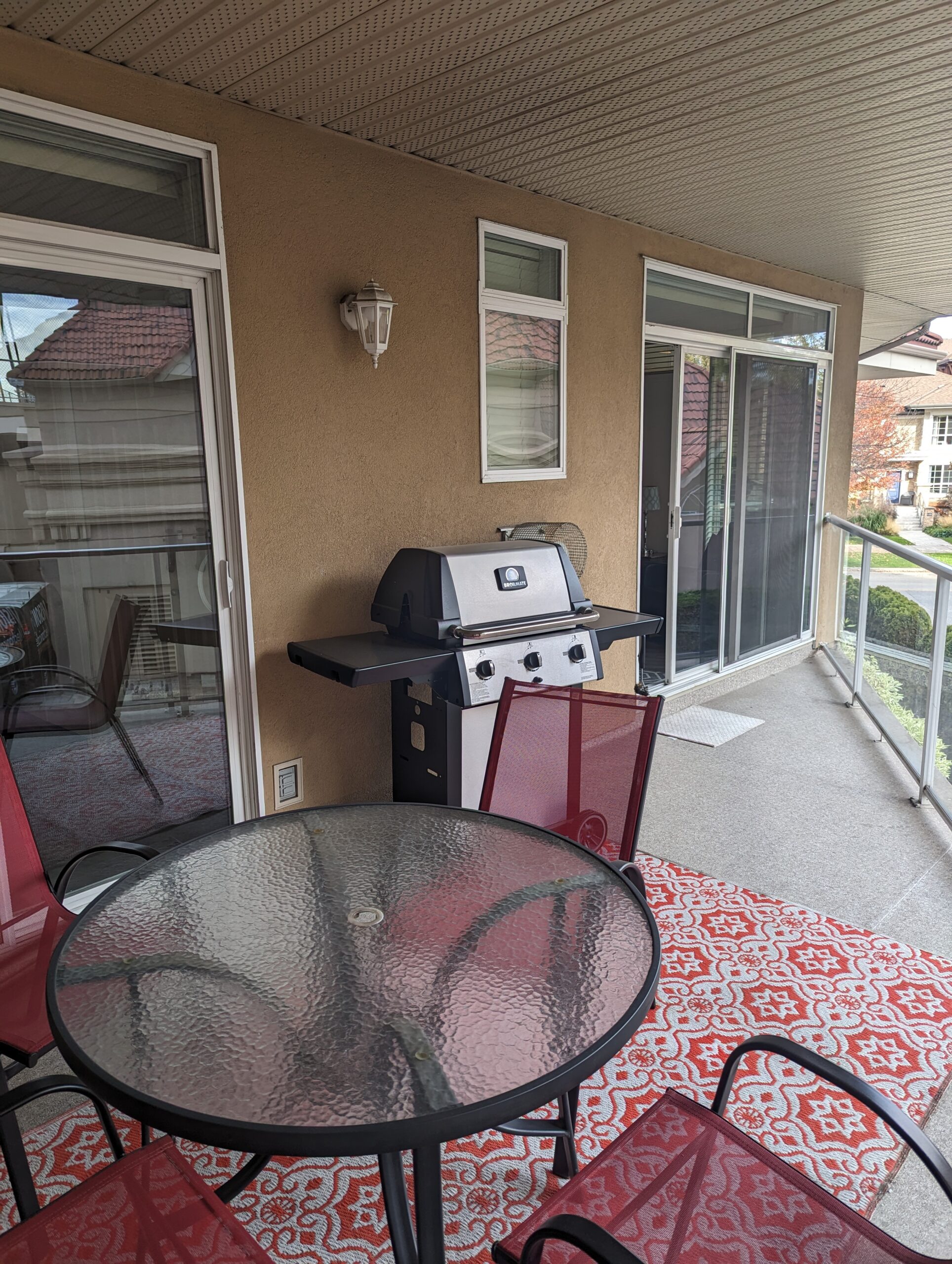 Patio with a Table, 4 chairs, BBQ, and two Patio Doors